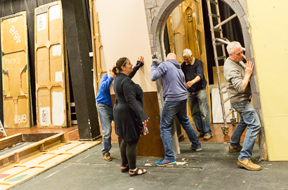 Set building society members erecting a large section of set in the theatre